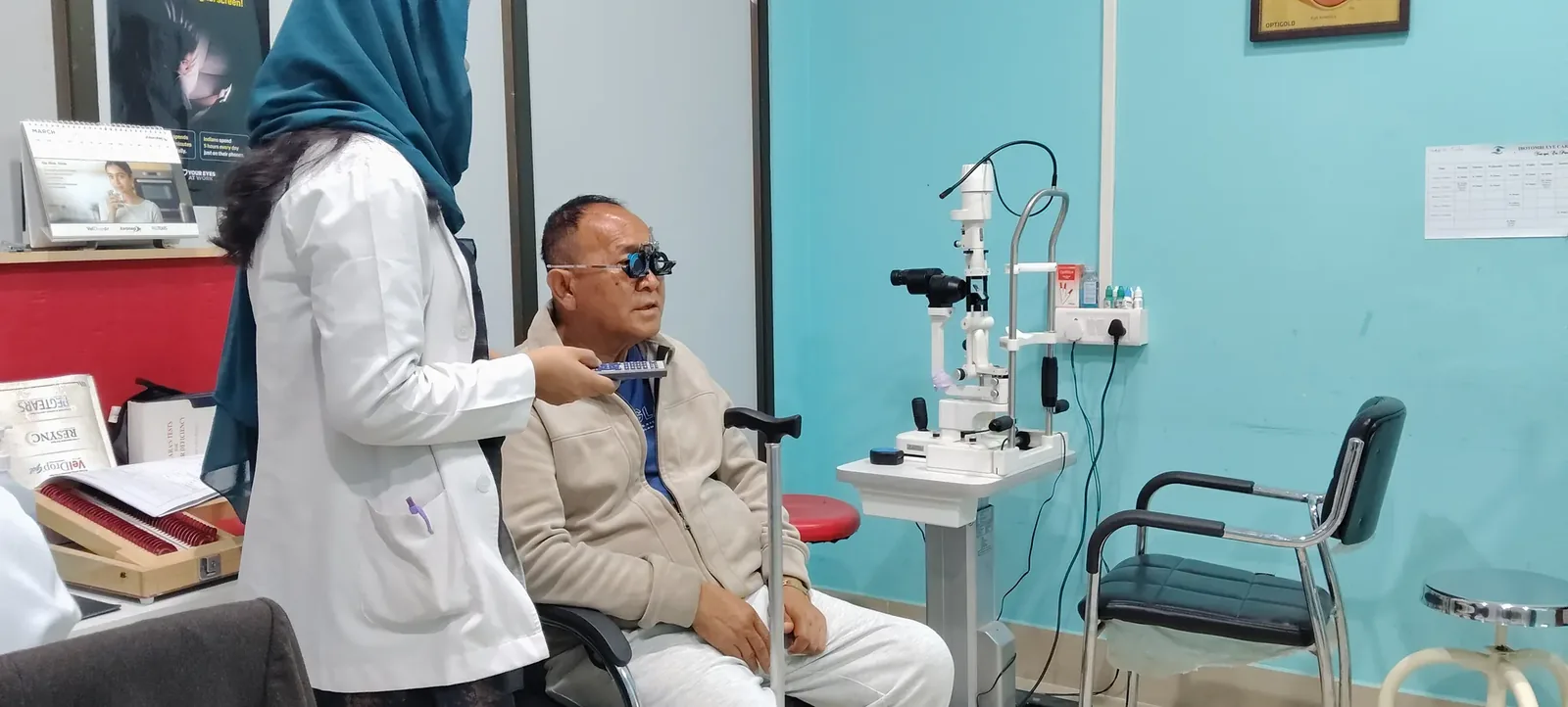 An optometrist assessing a patient's vision with a trial frame at Ibotombi Eye Care