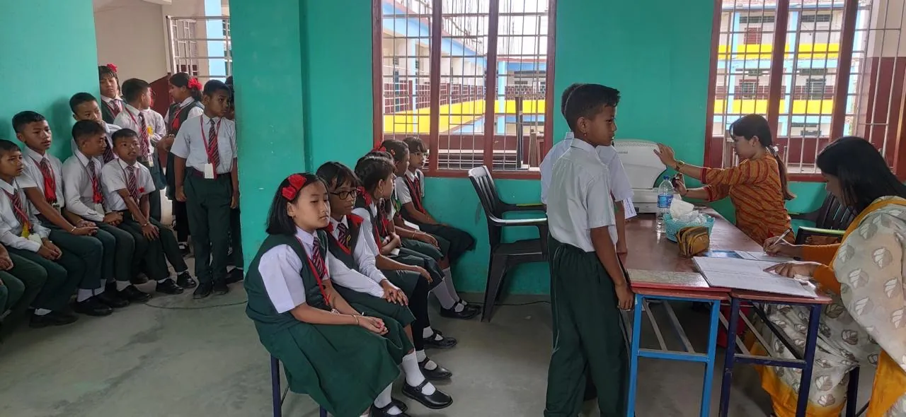 Students waiting in line and registering at an Ibotombi Eye Care school eye check-up workshop